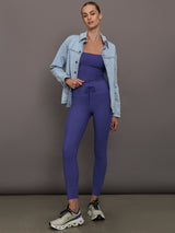 Model is wearing Melt High Rise Sport Pocket Legging in Future Dusk styled with matching top and denim jacket, full body view.