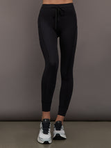 Front view of model wearing Ribbed Melt High Rise Pocket Legging in Black with drawstring waistband.