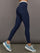 Model wears a buttery soft high waisted navy legging with thin white waistband. 