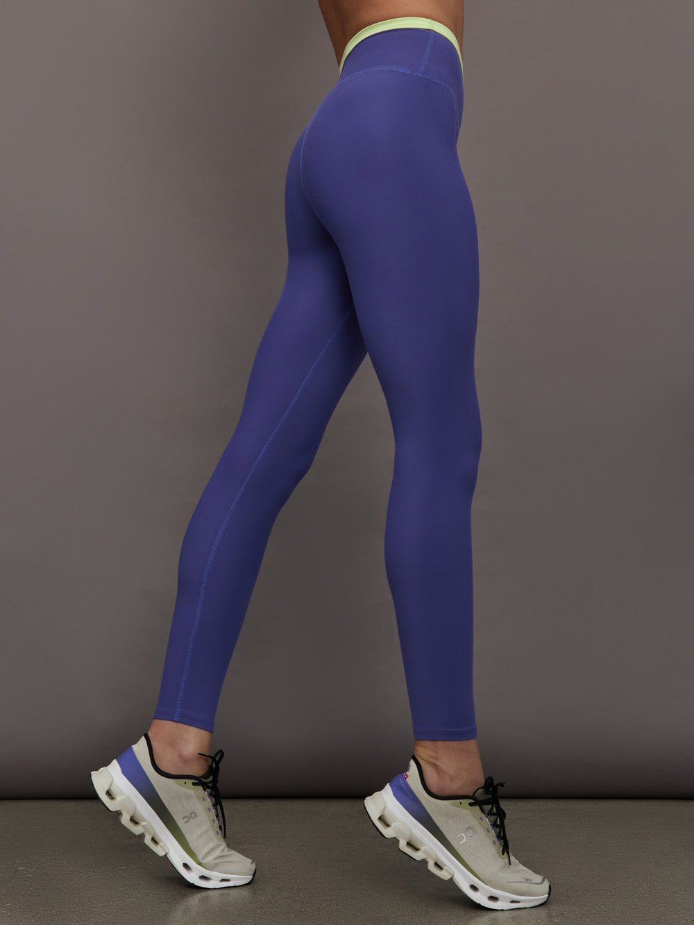 Model wearing blue leggings with bright green contrast on the waist