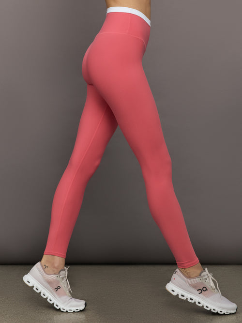 Model wears a buttery soft high waisted rosewood legging with thin white waistband. 