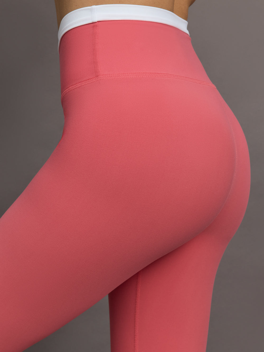 Model wears a buttery soft high waisted rosewood legging with thin white waistband. 