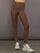 Model wearing high-rise ribbed leggings in cocoa brown, front view with fitted waistband and ankle-length design.