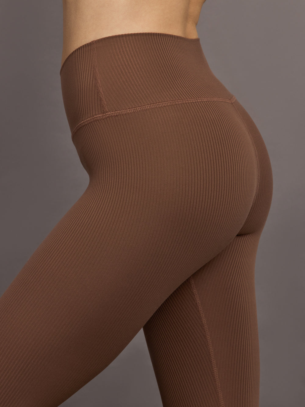 Close-up of ribbed cocoa brown high-rise leggings showing sculpted seam and textured rib knit fabric.