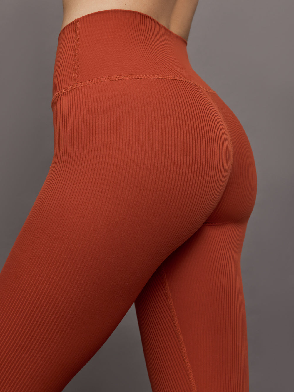 Close-up of ribbed terracotta high-rise leggings waistband and fit.