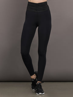 Model wears the Melt and Mesh Ruched Legging in Black, with ruched detailing at the waistband and breathable mesh for a sculpted look.