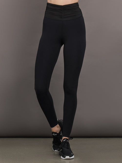 Model wears the Melt and Mesh Ruched Legging in Black, with ruched detailing at the waistband and breathable mesh for a sculpted look.