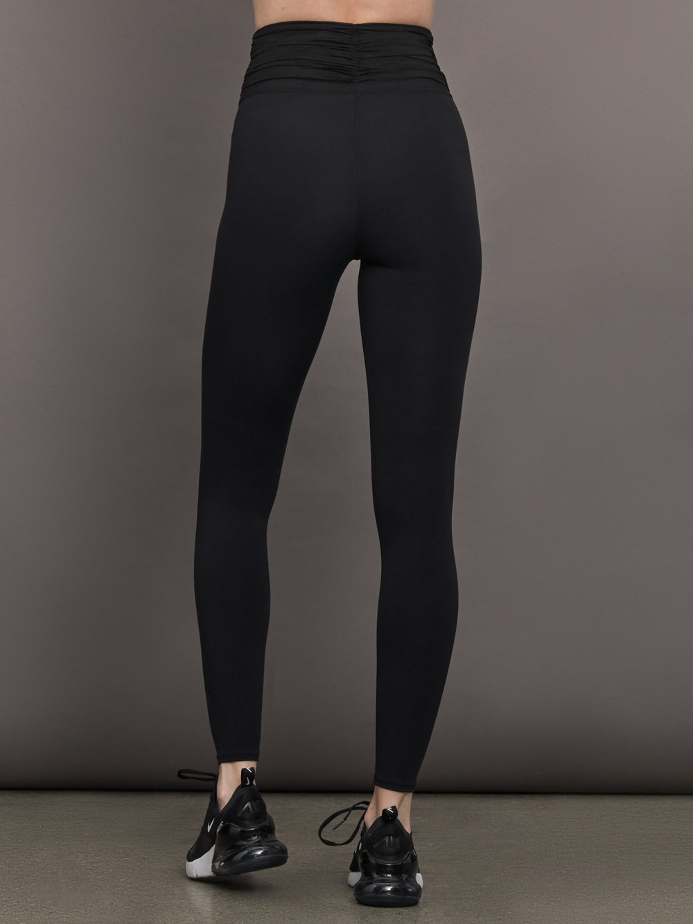 Model wears the Melt and Mesh Ruched Legging in Black, with ruched detailing at the waistband and breathable mesh for a sculpted look.