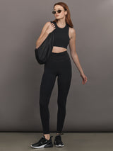 Model wears the Melt and Mesh Ruched Legging in Black, with ruched detailing at the waistband and breathable mesh for a sculpted look.