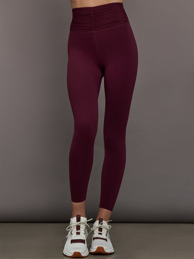 Model wearing Fig colored leggings with a rushed waist