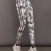 Model wears a pair of white leggings with burgundy toile print. 