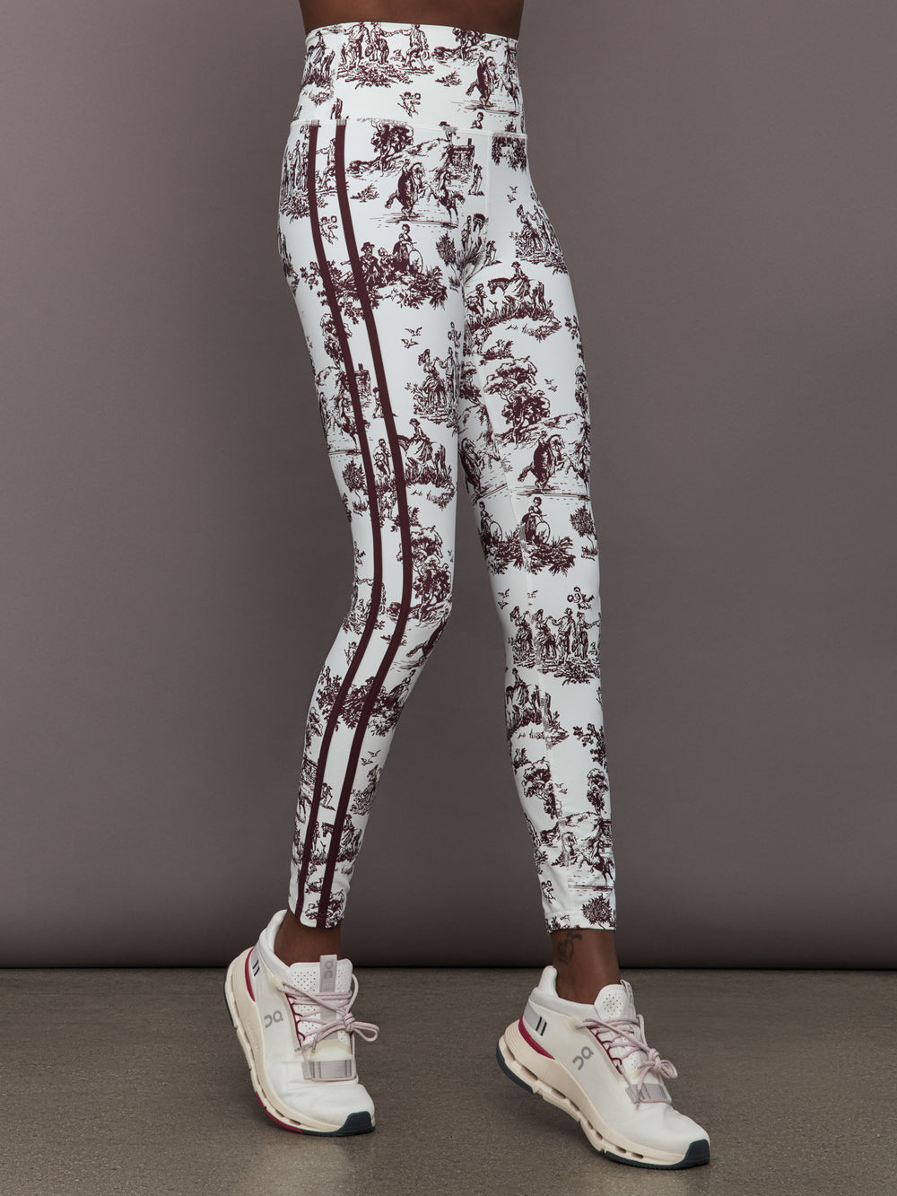 Model wears a pair of white leggings with burgundy toile print. 