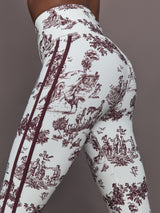 Model wears a pair of white leggings with burgundy toile print. 