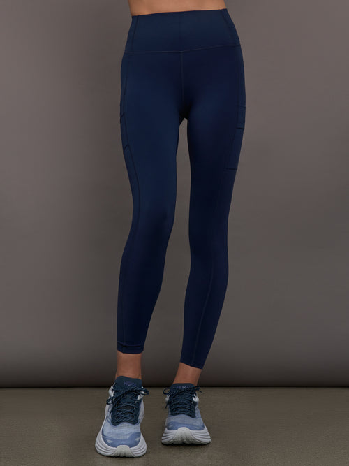 Model wearing Diamond Compression High Rise Pocket Legging Navy, front view.