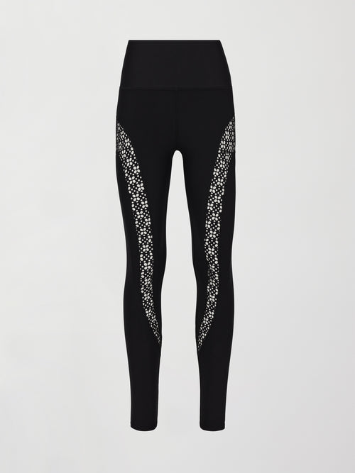 A pair of black high waisted leggings with laser cutouts along thighs. 