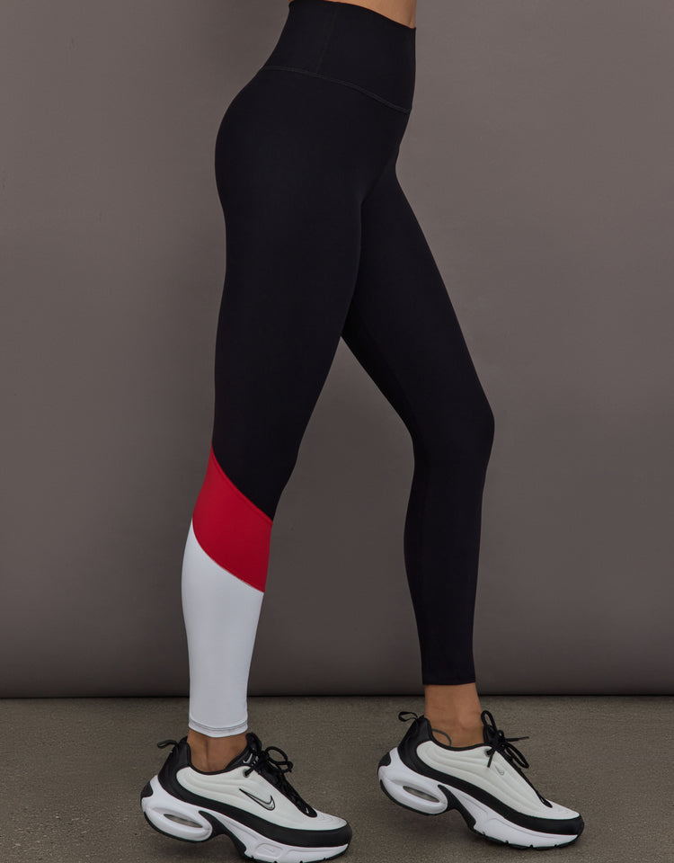 Model is wearing Melt high-rise colorblock legging in black crimson white, side view.