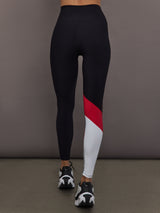 Model is wearing Melt high-rise colorblock legging in black crimson white, back view.