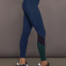 Model is wearing Melt High-Waisted Colorblock Legging in Navy, Black, and Forest, side view.