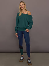 Model is wearing Melt High-Waisted Colorblock Legging in Navy, Black, and Forest, full body front view styled with sweatshirt.