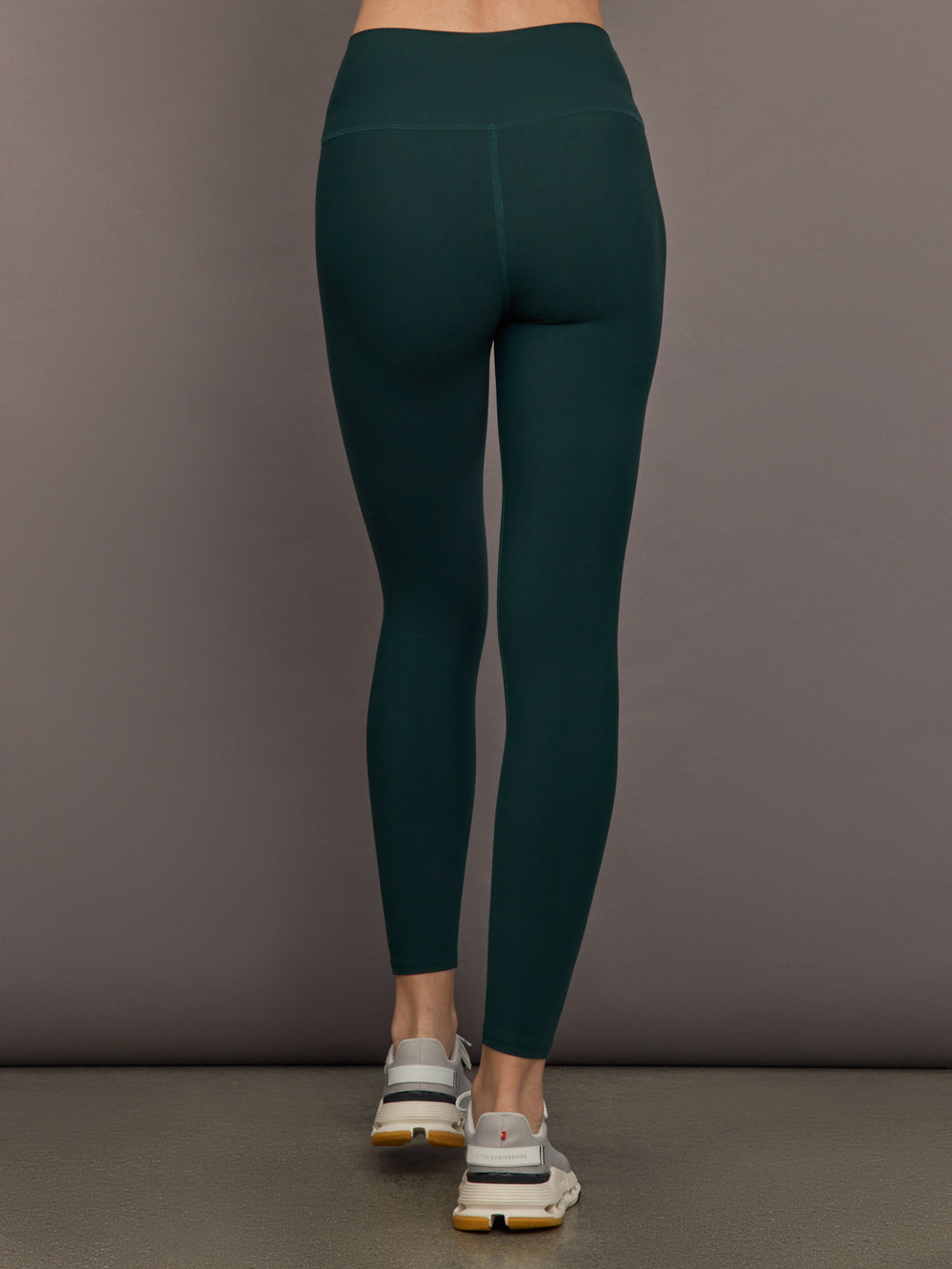 Model is wearing the High Rise Legging in Forest, back view.