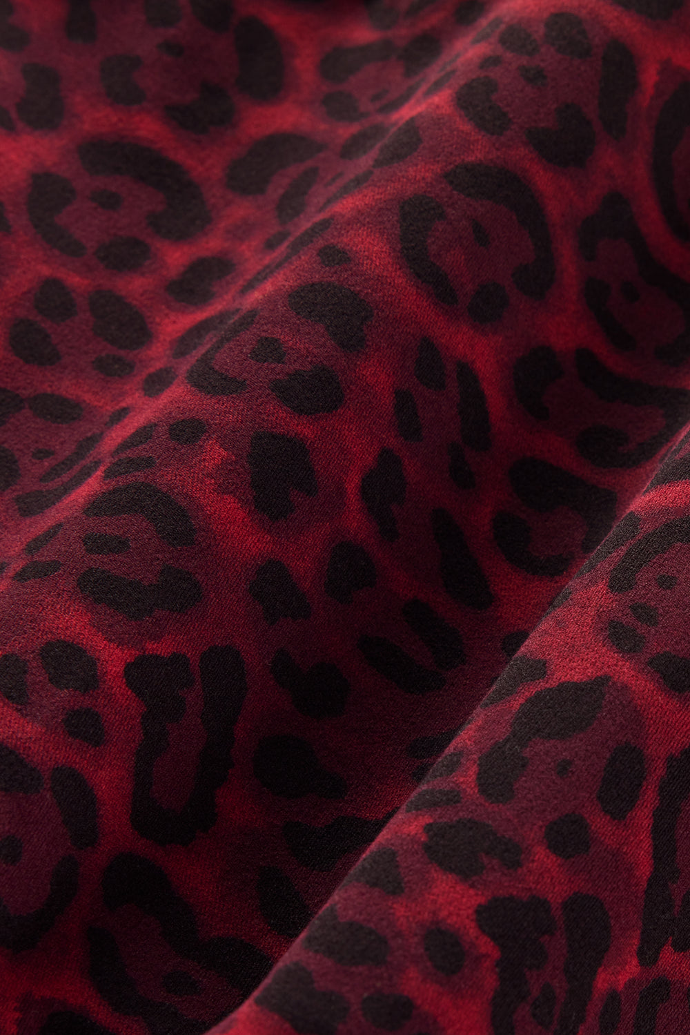 Close-up of Melt fabric in red leopard print, textured detail.