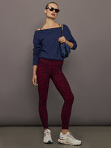 Red leopard Melt leggings with navy off-shoulder sweatshirt and sneakers, full outfit view.