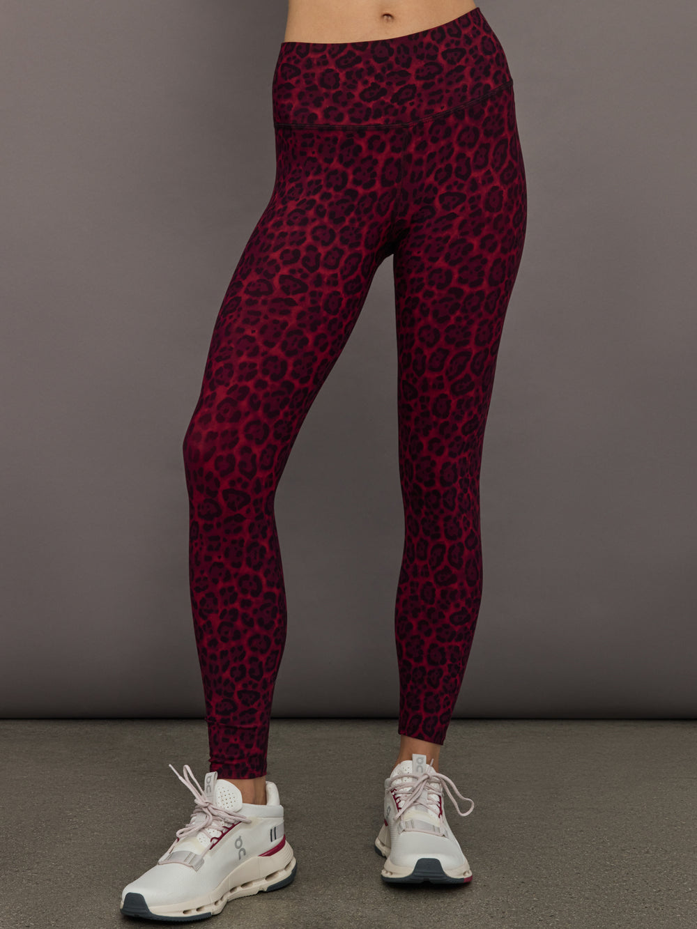 Model wearing high-rise Melt leggings in red leopard print, styled with white sneakers.