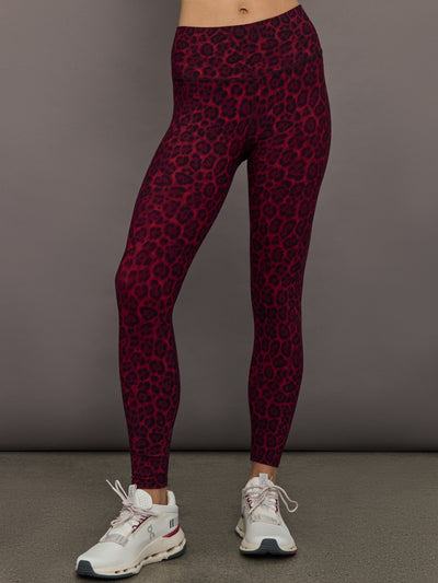 Model wearing high-rise Melt leggings in red leopard print, styled with white sneakers.