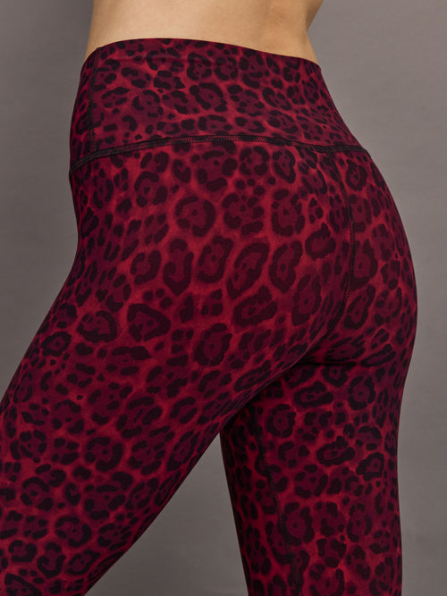 Waistband and hip seam detail of Melt leggings in red leopard pattern, close-up back view.