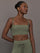 Model wears a buttery soft sports bra in army green with double straps and cross back design. 