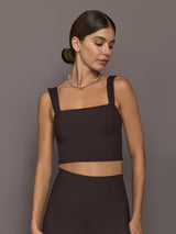 Model is wearing a dark brown square-neck cropped tank top with wide straps and a fitted silhouette, front view.