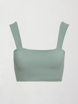 Model wears sage green bra top with a square neckline and wide shoulder straps.