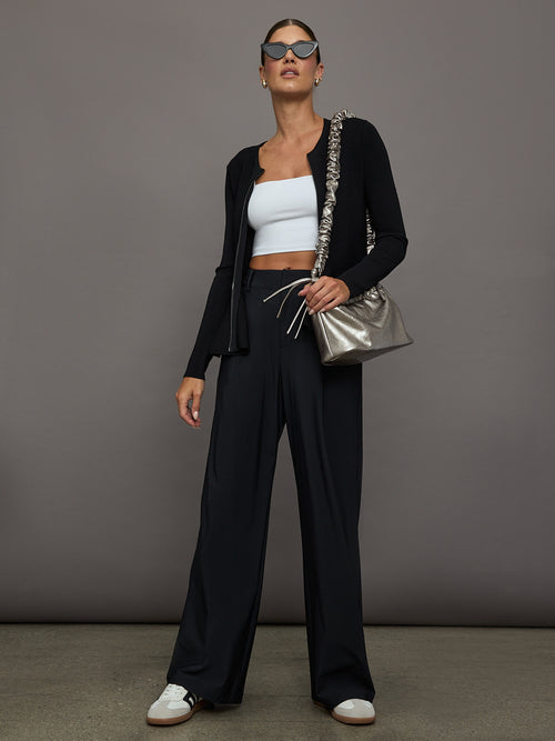 Model styled in Square Neck Bra Top in White with black cardigan, wide-leg pants, and metallic bag.