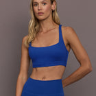 Model is wearing Rib Melt Racerback Sports Bra in Cobalt, front view.
