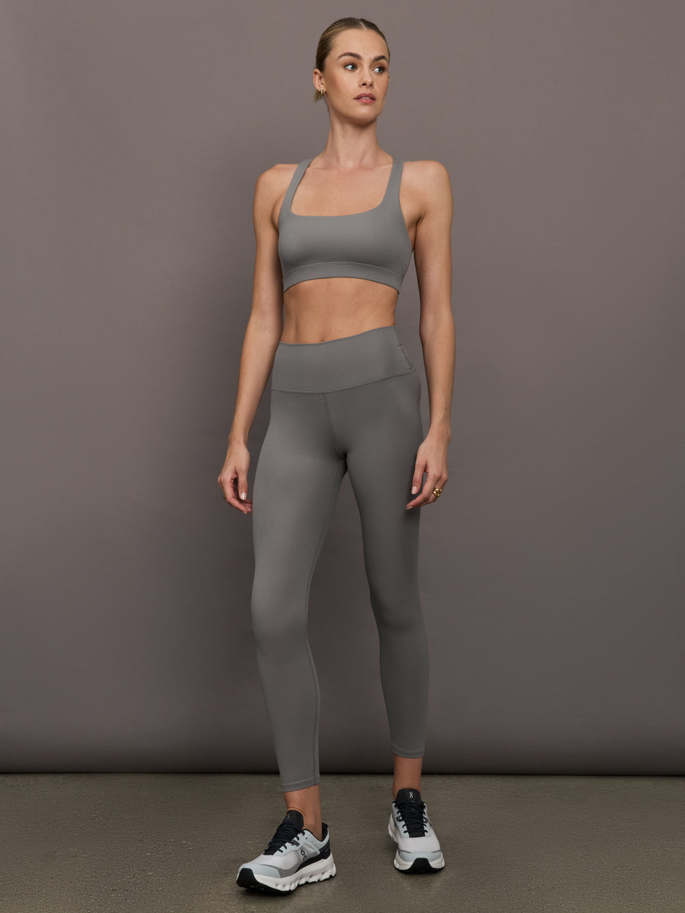 Model is wearing Ribbed Melt High Rise Legging in Steel Grey with matching sports bra, full body view.