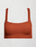 Model wears terracotta-colored racerback bra with a ribbed texture, square neckline, and wide straps that merge at the back.
