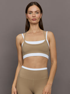 Model wears a white with chinchilla overlay sports bra perfect for medium impact activities. 