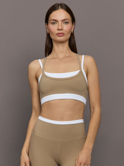 Model wears a white with chinchilla overlay sports bra perfect for medium impact activities. 