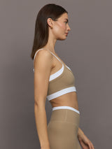 Model wears a white with chinchilla overlay sports bra perfect for medium impact activities. 