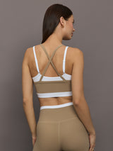 Model wears a white with chinchilla overlay sports bra perfect for medium impact activities. 