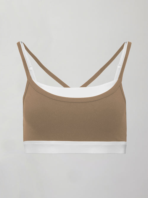Model wears a white with chinchilla overlay sports bra perfect for medium impact activities. 