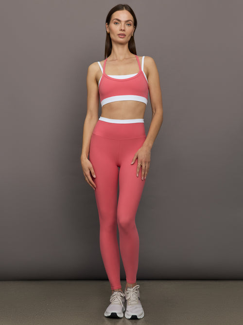 Model wears a white with rosewood overlay sports bra perfect for medium impact activities. 