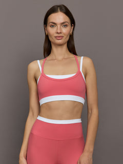 Model wears a white with rosewood overlay sports bra perfect for medium impact activities. 