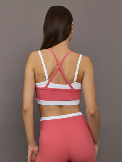 Model wears a white with rosewood overlay sports bra perfect for medium impact activities. 