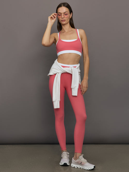 Model wears a white with rosewood overlay sports bra perfect for medium impact activities. 