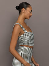 Side profile of model wearing houndstooth sports bra with wide straps and fitted silhouette.