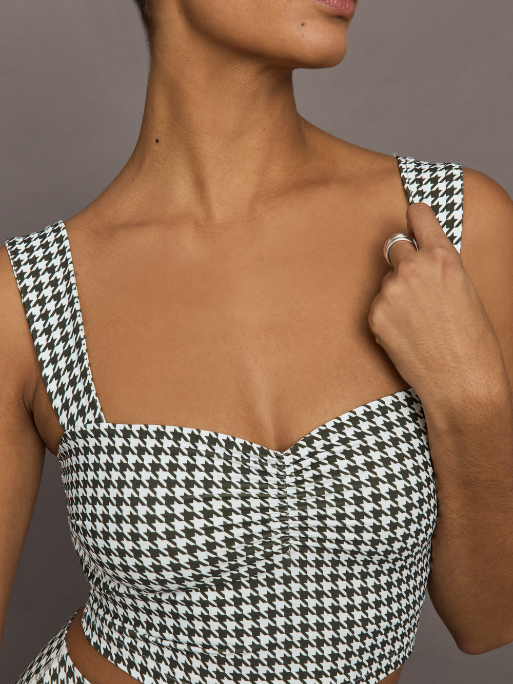Close-up detail of houndstooth sports bra highlighting ruched sweetheart neckline.