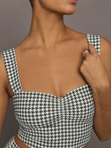 Close-up detail of houndstooth sports bra highlighting ruched sweetheart neckline.