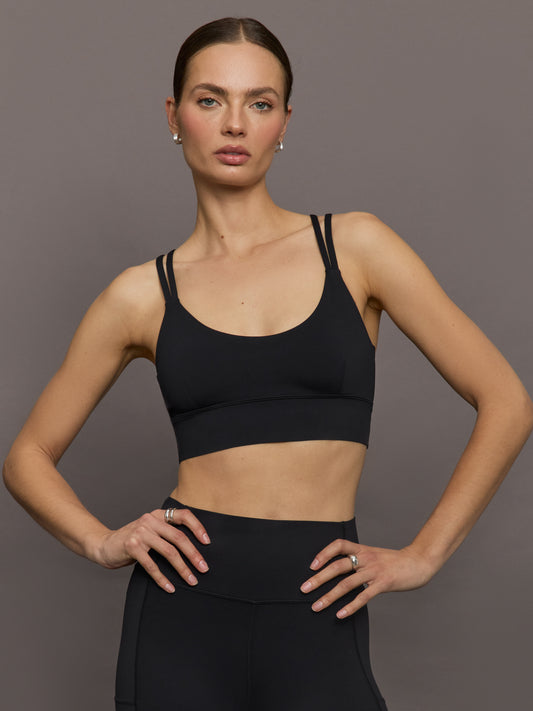 Model is wearing Diamond Compression Multi Strap Active Bra in Black, front view.