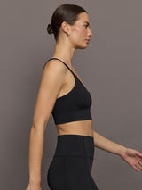 Model is wearing Diamond Compression Multi Strap Active Bra in Black, side profile view.